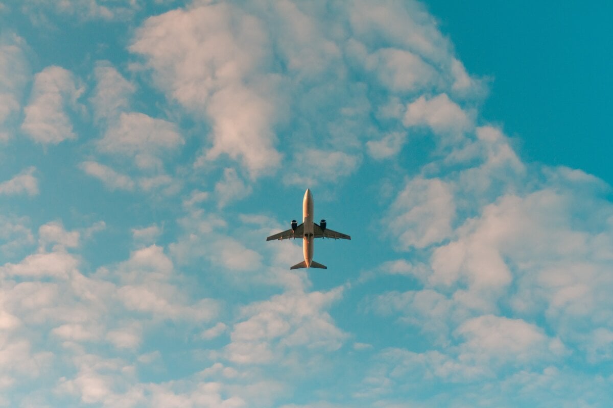 Plane in blue sky with soft clouds 